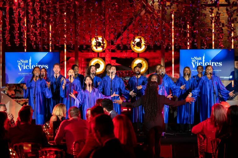 Chorale gospel en robes bleues sur scène lors du gala Nuit des Victoires BPVF 2024, ambiance corporate immersive
